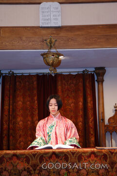 IDAHO. Boise. Asian Jewish girl standing at bimah in synagog