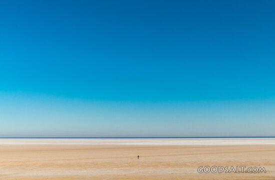 Single person on large salt lake.